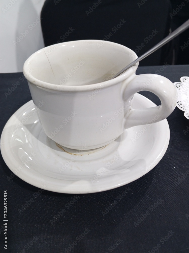Obraz premium Empty Dirty White Ceramic Coffee Cup with Saucer and Spoon After Drinking