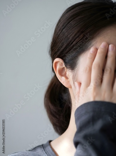 Woman with dark hair covering her face