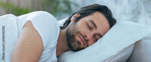 Bild auf Leinwand Relaxed Caucasian Male In His 30s Sleeping Peacefully On Pillow At Home, Undisturbed In Bedroom