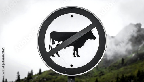 A black and white sign with a cow silhouette and diagonal line