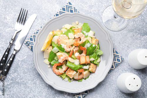 Tableau sur toile Delicious Caesar salad with shrimps served on grey table, flat lay