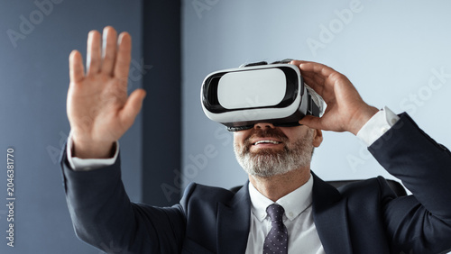 Foto Focused Middle-aged Caucasian Man Wearing Vr Headset Engaging With Virtual Environment At Modern Office Setting