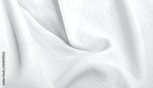 Close-up of pristine white leather, draped and textured, with soft folds and subtle shadows. The surface is smooth with a natural grain