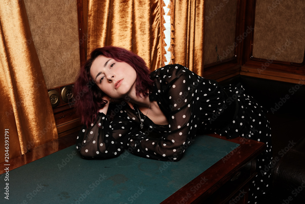 Fototapeta premium Charming woman relaxing in vintage interior with rich fabrics