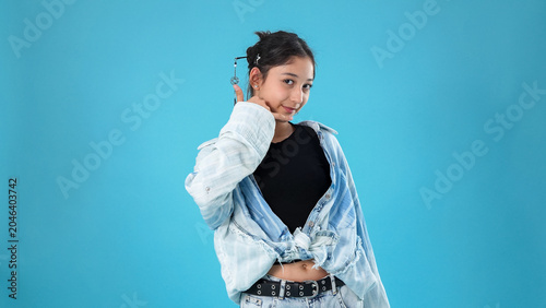 Confident happy woman posing sideways looking back on blue backdrop