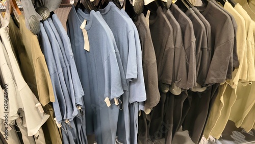 Quadro su tela Colorful blank t-shirts hanging on clothing rack in retail store, basic cotton s