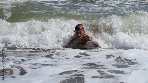 Boy dive into a foaming wave. Live a healthy life. Be H3althy