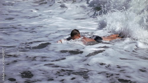 Boy dive into a foaming wave. Live a healthy life. Be H3althy