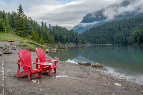 Red chairs on the shore of Two Jack Lake in Banff National Park, Alberta, Canada