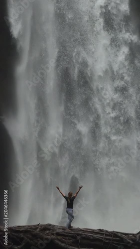 Cinematic slow motion of woman standing by Nungnung waterfall Bali