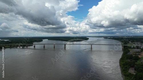 Aerial view of bridge over wide river with boat wake