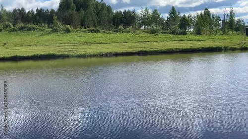 Scenic landscape of a tranquil river with lush greenery and cloudy sky
