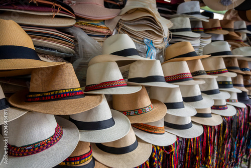 Traditional Ecuadorian toquilla straw hats with woven bands displayed at a market in Otavalo