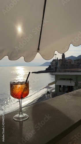 Enjoying a drink by the sea in Camogli, Italy during sunset with stunning views of the coastline