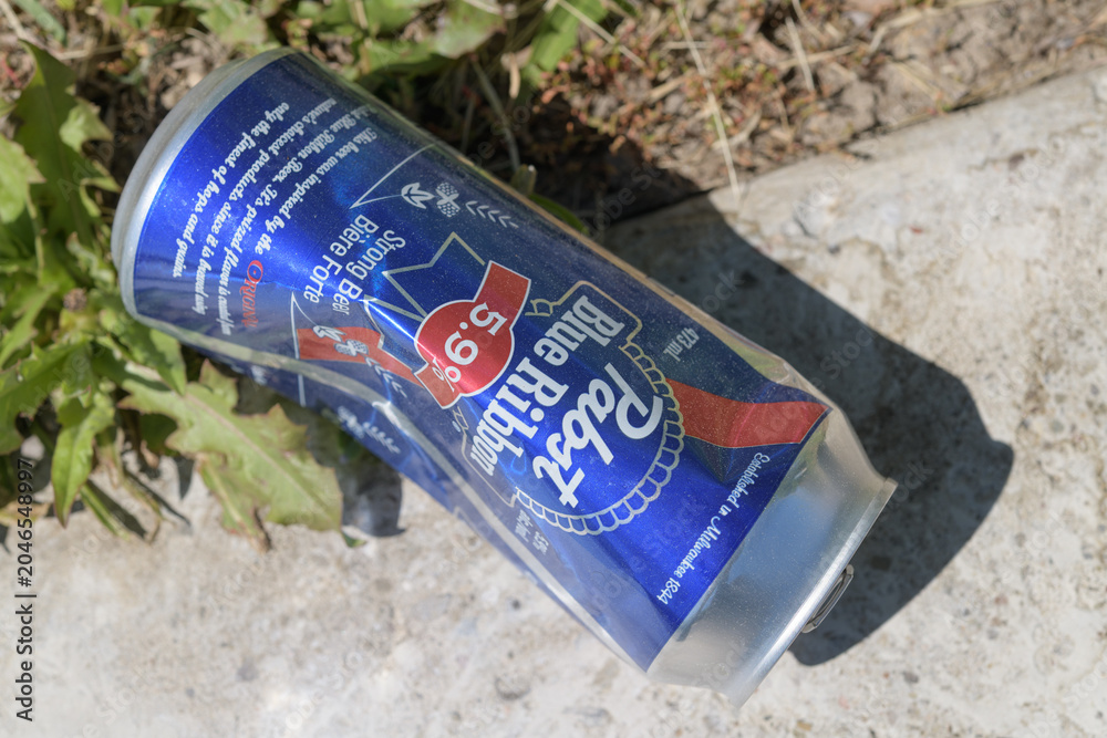 Naklejka premium slightly crushed, discarded aluminum can of Pabst Blue Ribbon 5.9% alc strong beer outdoors, Toronto