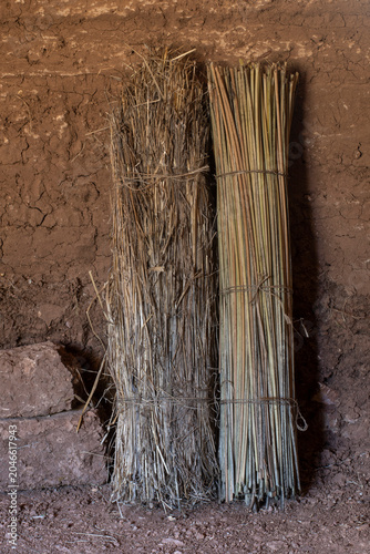 Primitive rolled mats leaning against adobe wall