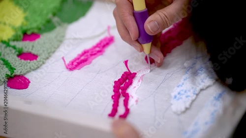 Creating textured yarn art on fabric during craft workshop