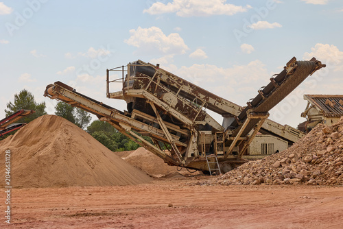 Industrial crushing machine processing aggregates in quarry site