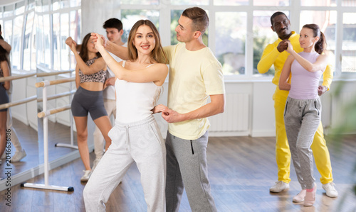 Canvas Print Graceful young girl and boy training waltz dance poses in dancehall during worko
