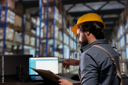 Foto Industrial employee reviewing cargo shipment details files, working on quality control and logistics in storage room