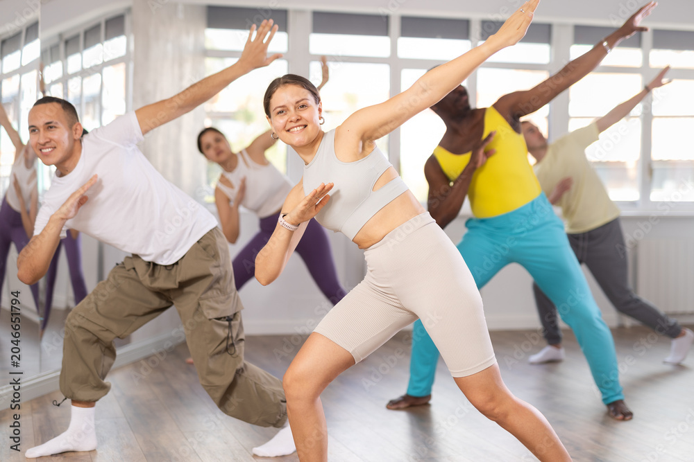 Obraz premium Group of multiethnic men and women rehearsing hip hop dance in studio