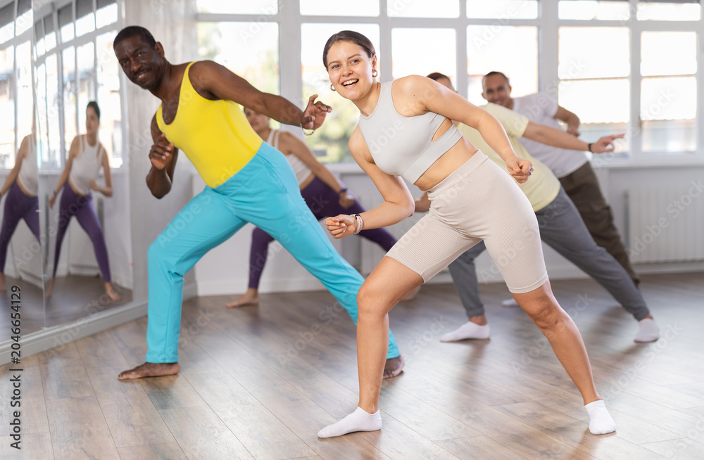 Obraz premium Group of multicultural men and women dancing modern dance in studio
