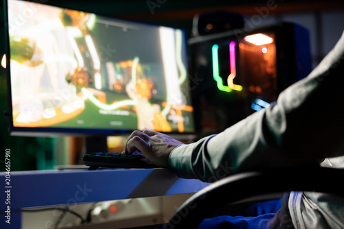 Obraz na plátně Guy playing first person shooter videogame with automatic gun shooting laser bullets at flying robotic foes