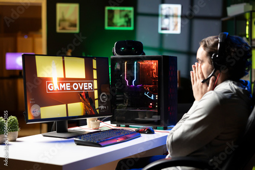 Schilderij op canvas Sad gamer upset after losing online multiplayer action videogame championship, being defeated by rivals
