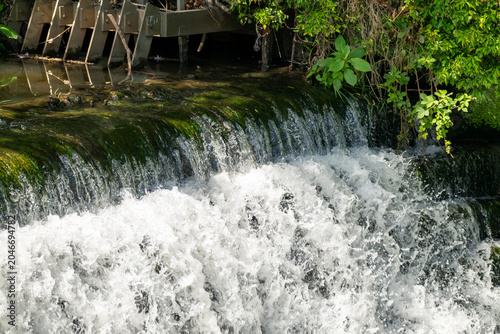 Riverside ecology - A cascading waterfall on a countryside river