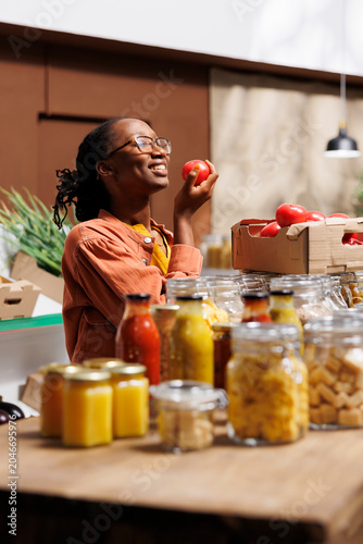 Canvas Print Selective focus on black woman at zero waste store smelling organic farm-grown tomato