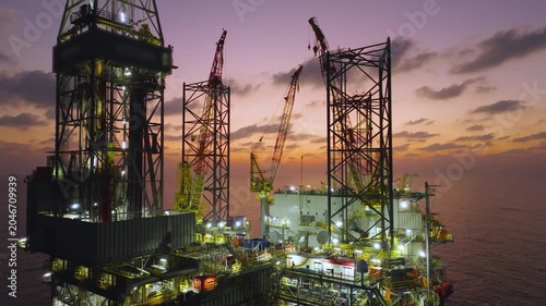 Aerial view of offshore jack up rig and offshore platform during sunset for oil and gas exploration and production. 