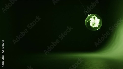 A glowing green glass orb suspended in mid-air emits fire-like light
