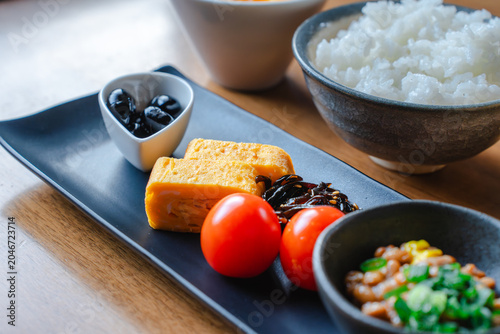 Schilderij op canvas 長皿に盛られた卵焼きとミニトマト、手前の納豆にフォーカスした和食のアップ写真。レシピサイトやメニュー用