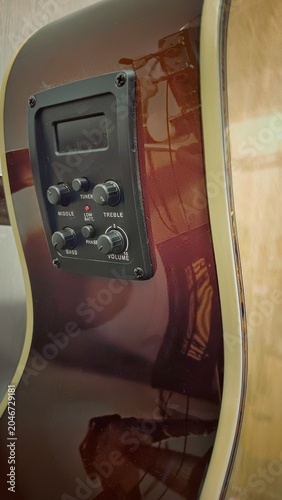 Obraz na plátně Black preamp control panel mounted on the glossy sunburst side of an acoustic-electric guitar, featuring labeled rotary knobs for volume, bass, middle, treble, phase and tuner display