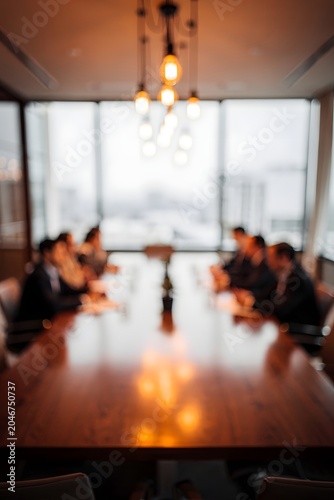 Modern business meeting in contemporary office with professionals gathered around conference table during collaborative planning session