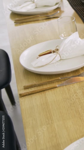 Vertical video: Panning camera revealing dining table in home, preparing meal with salad, napkins