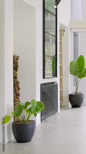Vertical video: Panning camera revealing curved sofa with nested tables at home, showing garden