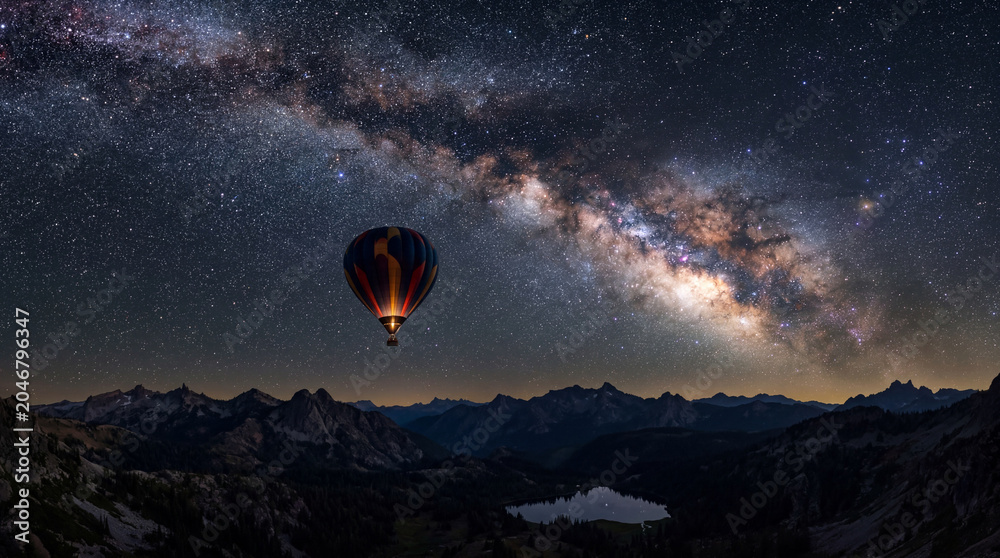 Obraz premium Beautiful hot air balloon flying under brilliant starry night sky with glowing milky way galaxy