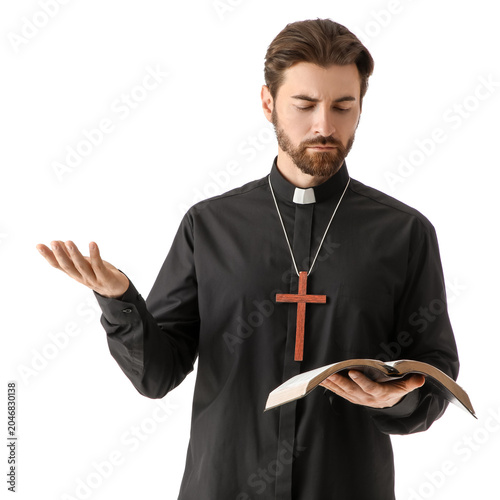 Handsome priest reading Hol...