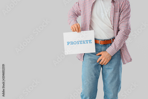 Young man holding paper wit...