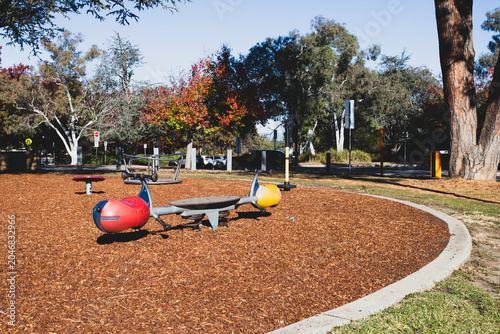 Colorful Playground Seesaw in Park on Sunny Autumn Day - Left Angle