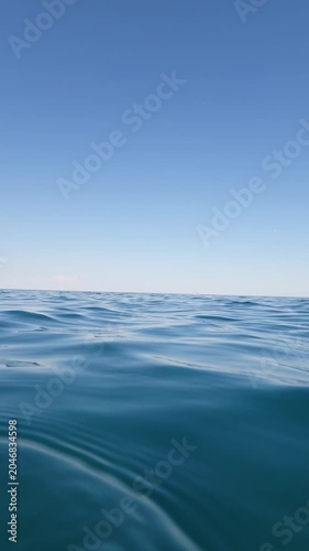 Blue sea waves and clear sky in summer from water level