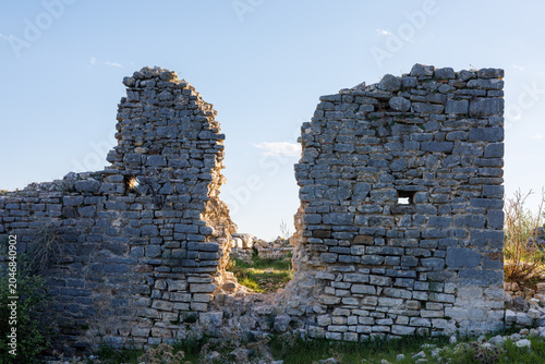 Foto Stone ruins of an old masonry wall under a clear blue afternoon sky