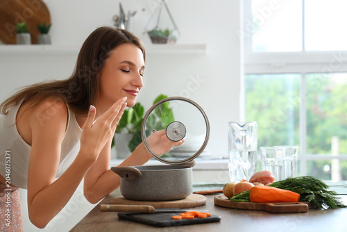 Young woman cooking chicken...