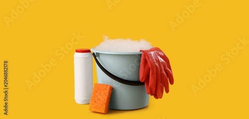 Bild auf Leinwand Plastic bucket with foam solution, rubber gloves, sponge and bottle of detergent