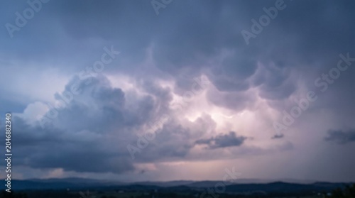 фотографія Soft diffuse storm glow breaking through dense overcast dark clouds before a sev