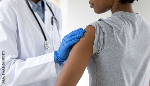  Healthcare worker providing patient care, carefully examining an arm while wearing protective gloves.