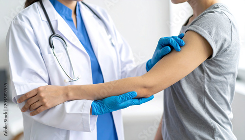 Doctor wearing blue medical gloves gently treating a patient's arm, professional healthcare setting.
