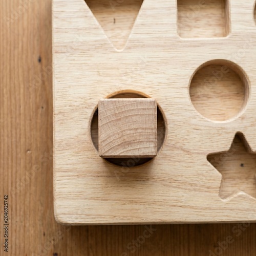 Square Wooden Block Pushed Into Round Hole on Sorting Board, Mismatch and Wrong Fit Concept