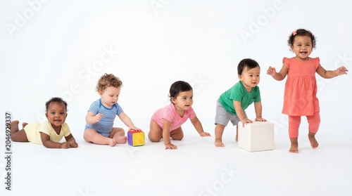 Developmental Milestones: Five diverse babies engage in playful exploration, showcasing different stages of early mobility from crawling to standing, highlighting infant development and curiosity.